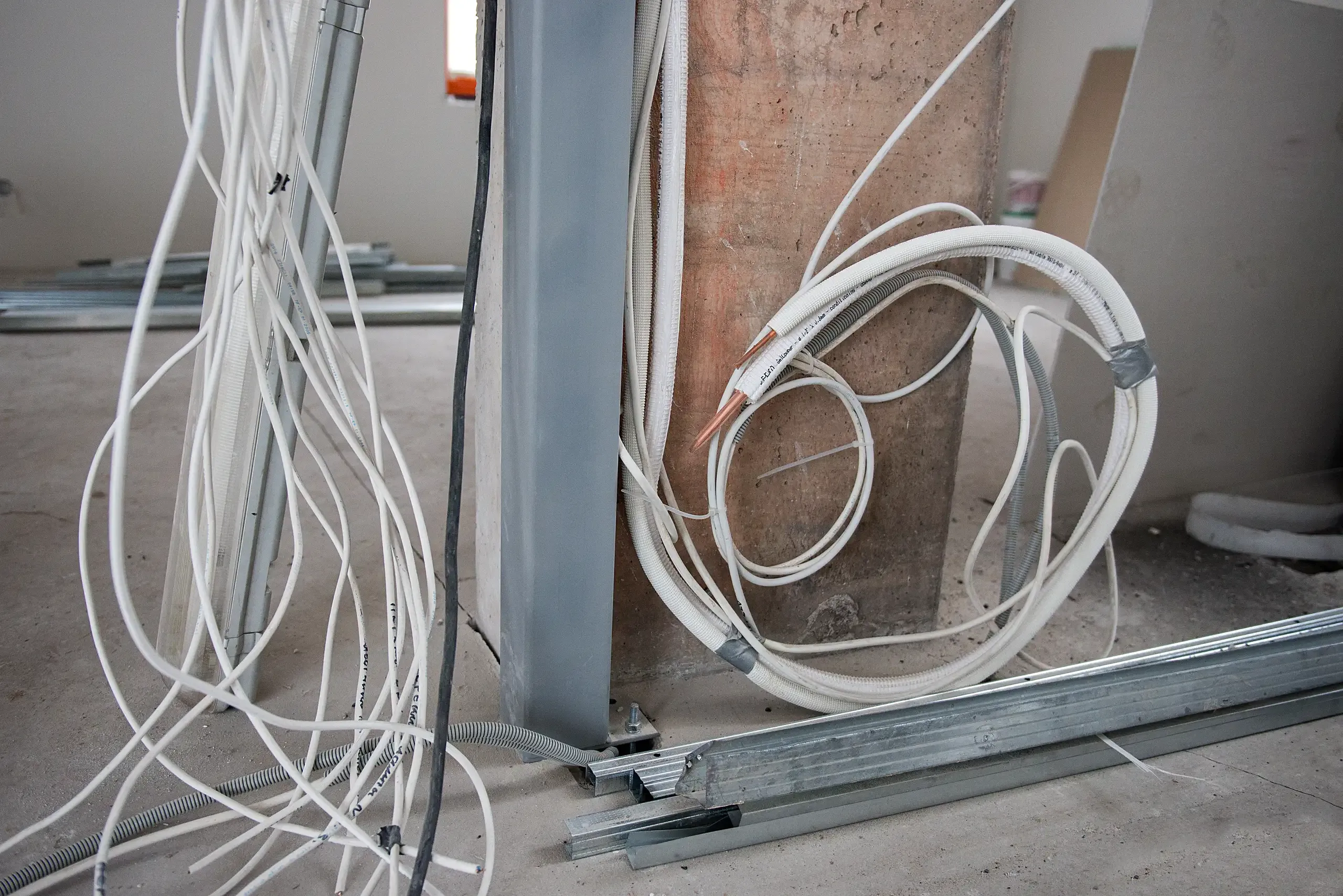 Fragment instalacji elektrycznej z rozprowadzonymi przewodami w nowym wnętrzu budynku