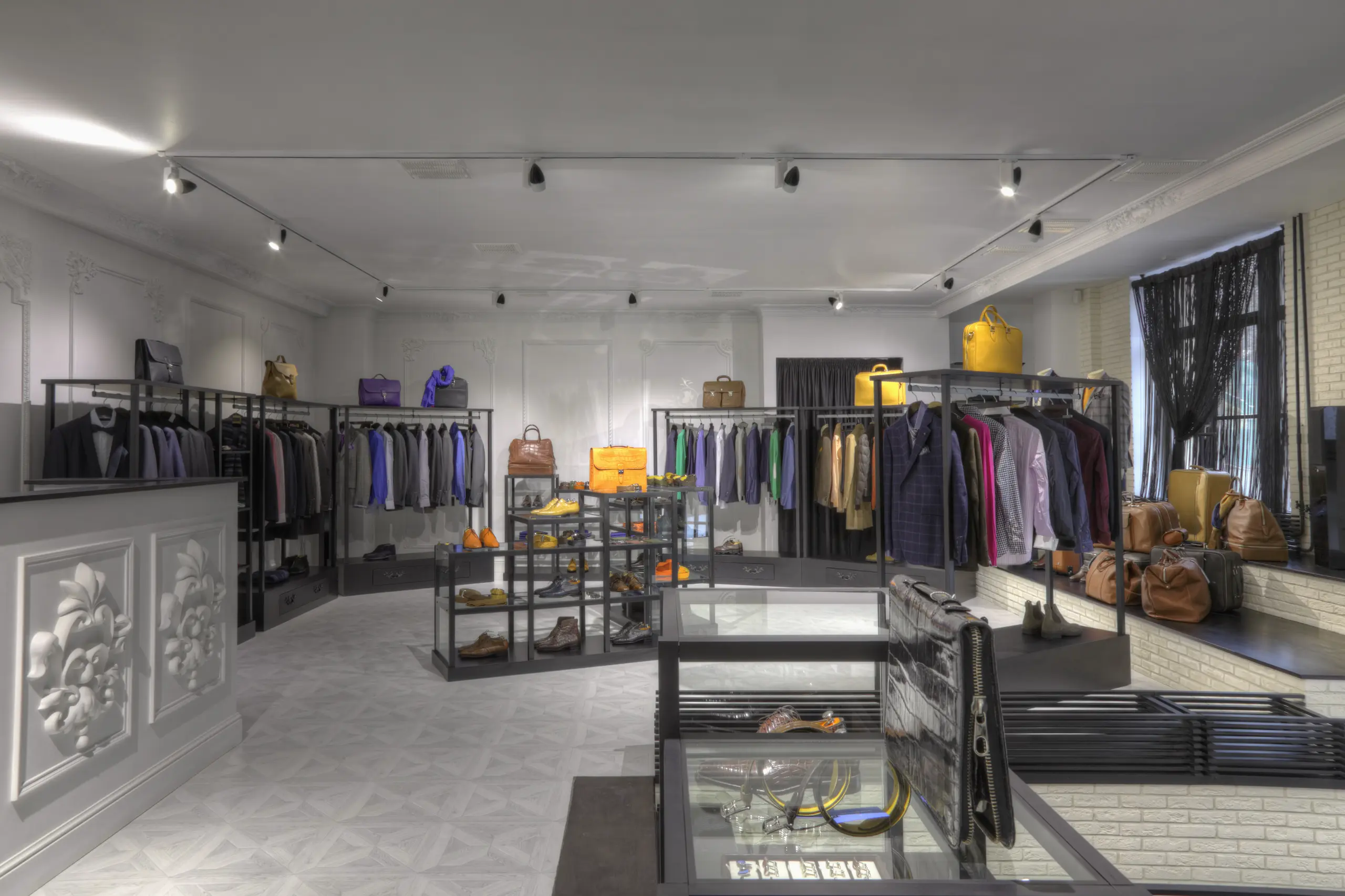 Wnętrze butiku z elegancką odzieżą i dodatkami, zaaranżowane w nowoczesnym stylu